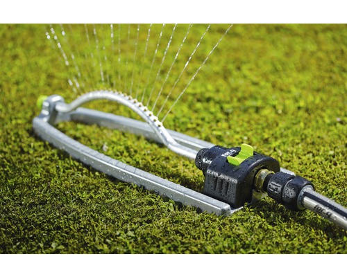 Schwinghebelregner aus Metall auf Rasen mit Wassersprühstrahlen