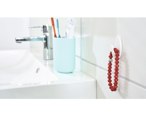 Badezimmer mit Waschbecken, Armatur, Zahnputzbecher und Haken mit Kette