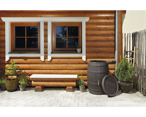 Façade de maison en bois avec fenêtres, banc, récupérateurs d''eau de pluie et plantes
