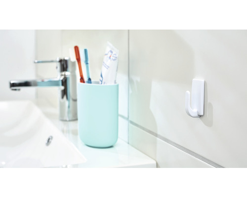 Scène de salle de bain avec lavabo, robinet, gobelet à brosses à dents avec brosses à dents et crochet mural