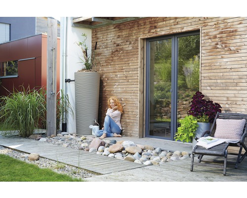 Jardin avec réservoir d''eau de pluie, douche extérieure et terrasse en bois.