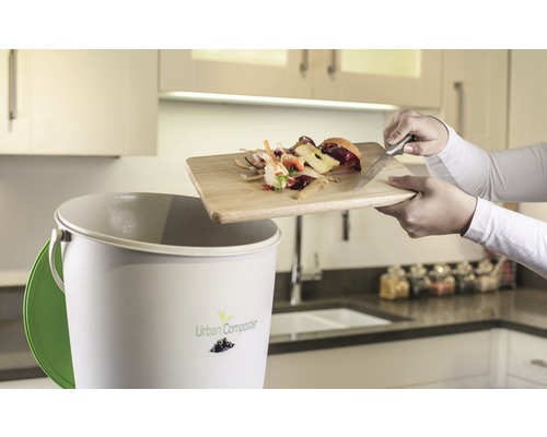 Poubelle à compost dans la cuisine avec des restes de légumes