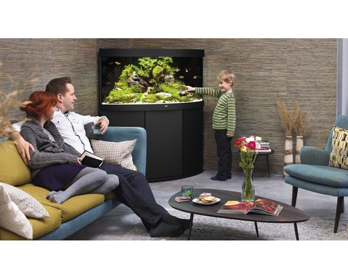 Wohnzimmer mit Aquarium, Familie auf dem Sofa und Kind am Aquarium