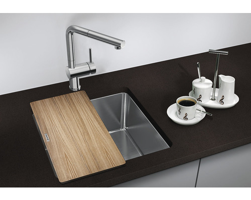 Évier de cuisine avec planche à découper, robinet et service à café sur un comptoir de cuisine