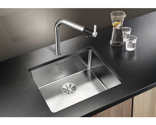 Edelstahlspüle mit Wasserhahn auf dunkler Arbeitsplatte