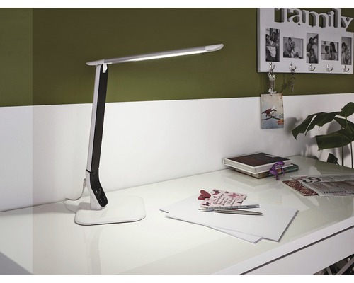 LED-Tischleuchte auf einem Schreibtisch mit Büromaterial