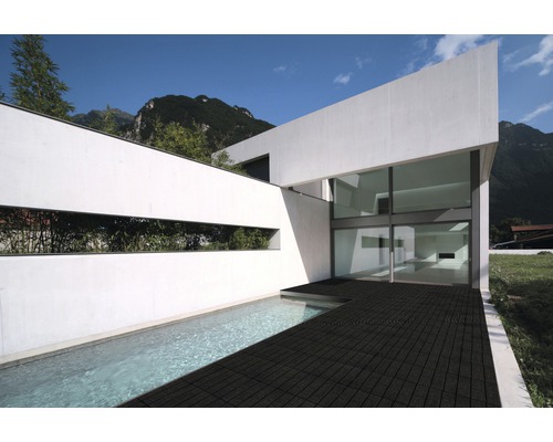 Maison moderne avec piscine et terrasse au sol foncé.