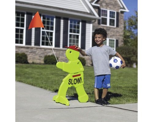 Panneau de signalisation avec l''inscription Lentement et un garçon avec un ballon de football