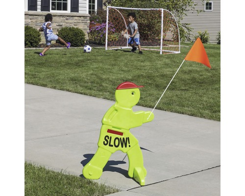 Panneau de sécurité pour enfants avec l''inscription ''Ralentir !'', avec des enfants jouant au football en arrière-plan