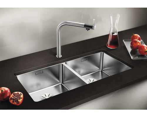 Double évier en acier inoxydable avec robinet sur un plan de travail foncé