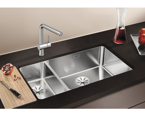 Évier en acier inoxydable à deux cuves et robinet de cuisine sur un comptoir de cuisine.