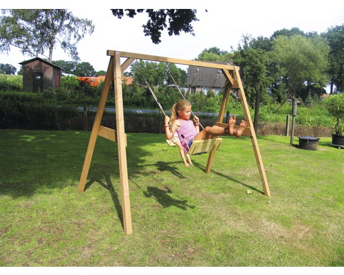 Balançoire en bois avec un enfant se balançant dans le jardin.