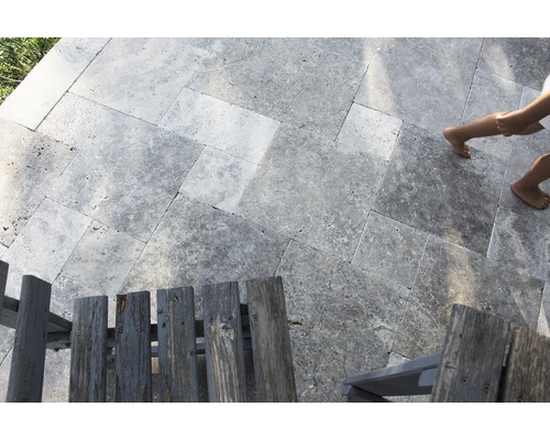 Pose de travertin à l''extérieur avec des chaises en bois