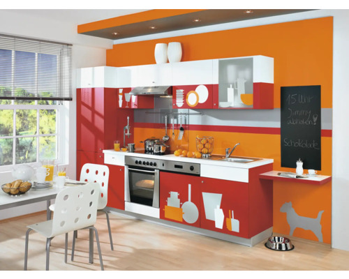 Cuisine lumineuse avec meubles de cuisine en blanc et rouge, table à manger avec chaises et décoration.