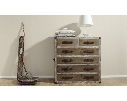Holzkommode mit mehreren Schubladen und Ledergriffen, ergänzt durch Lampe und Dekoration.
