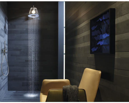 Salle de bains avec douche, pommeau de douche, mur carrelé, chaise et œuvre d''art