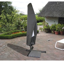 Abgedeckter Sonnenschirm auf einer Terrasse mit Garten im Hintergrund