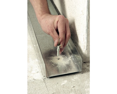 Hand befestigt Dübel mit Schraube in ein Metallprofil.