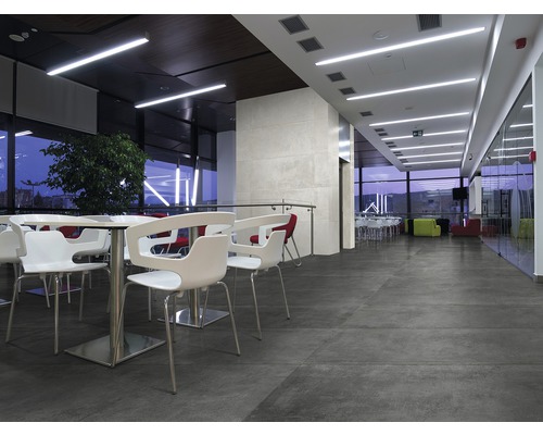 Innenraum mit Sitzgelegenheiten, Tischen und grossformatigen Bodenfliesen für ein modernes Ambiente.