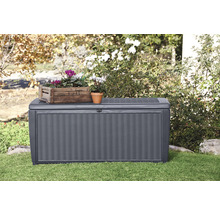 Scène de jardin avec un coffre de jardin gris, décoré de plantes