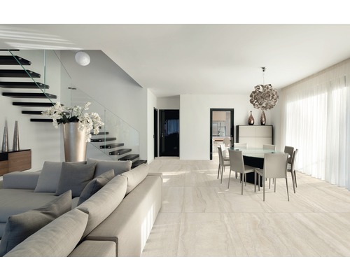 Heller Wohnraum mit Treppe, Sitzgruppe und Essbereich auf Fliesenboden