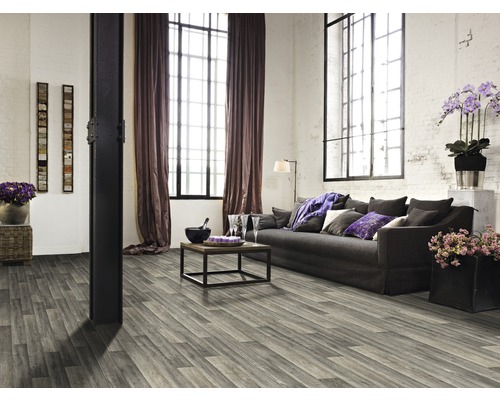 Salon avec plancher en bois gris, canapé et grandes fenêtres