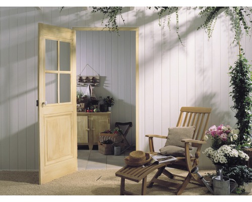 Une porte en bois avec des vitres mène à une pièce lumineuse avec des lambris en bois et des meubles de jardin