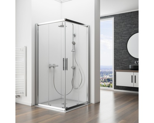 Douche d''angle avec portes en verre et ensemble de douche dans une salle de bains avec meuble sous-lavabo et miroir.