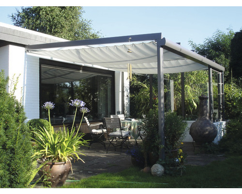 Terrasse avec toit de terrasse, table et chaises dans le jardin.