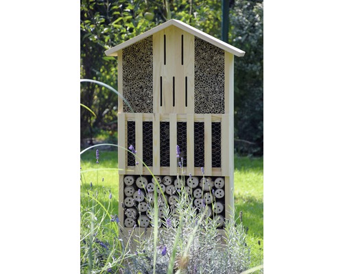 Hôtel à insectes en bois avec différents matériaux de remplissage dans le jardin