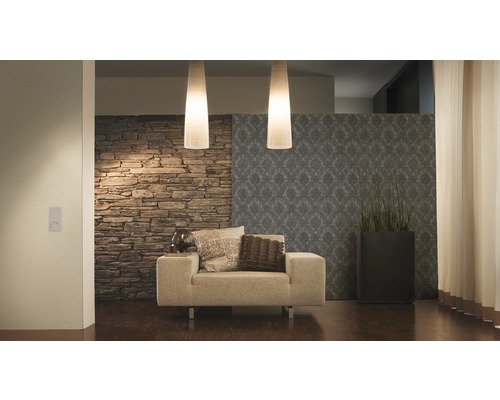 Salon avec fauteuil, mur décoratif en pierre et suspensions