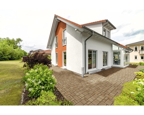 Einfamilienhaus mit gepflasterter Terrasse und Gartenanlage