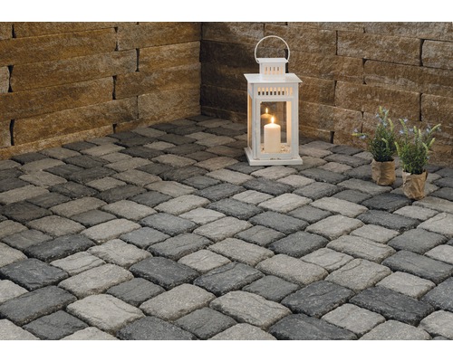 Scène avec pavés, lanterne et plantes en pot.