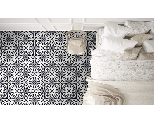 Schlafzimmer mit gemustertem Teppich, Bett und Stuhl