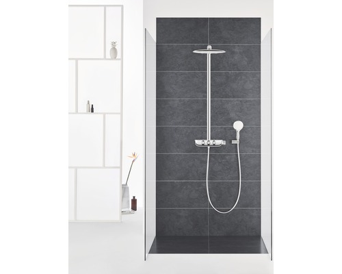 Duschsystem mit Kopfbrause und Handbrause in einem Badezimmer mit dunklen Fliesen.