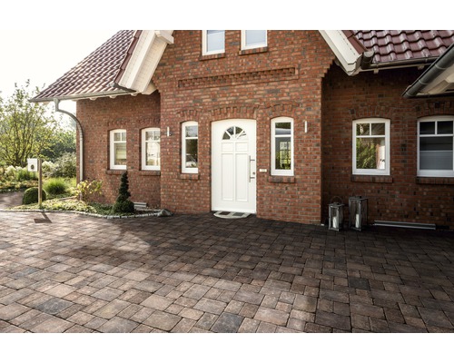 Aussenaufnahme eines Wohnhauses mit Pflastersteinen auf dem Vorplatz.