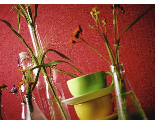 Nature morte décorative avec des fleurs en bouteille et des tasses empilées.