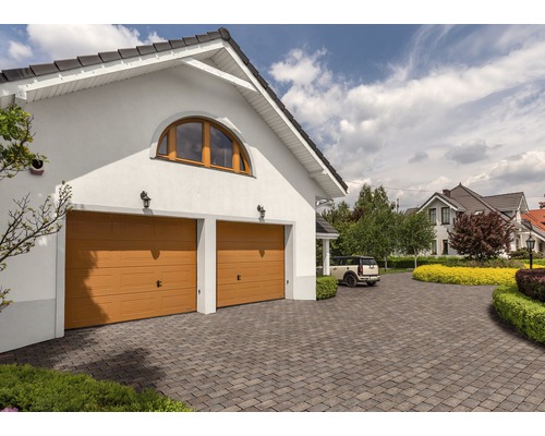 Garage double avec deux portes sectionnelles et allée pavée devant une maison d''habitation