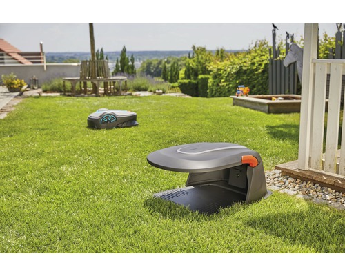 Deux robots tondeuses dans un jardin avec pelouse et mobilier de jardin.