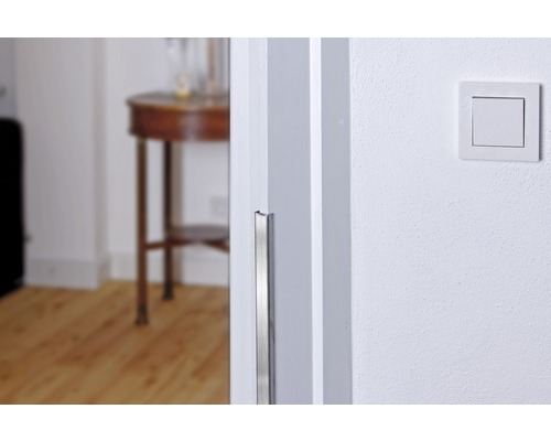 Nahaufnahme eines Türrahmens mit Kantenschutz und einem Lichtschalter an der Wand.