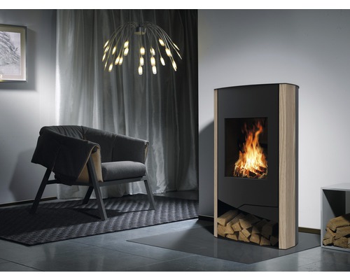 Wohnzimmer mit Kaminofen, Sessel und Lampe