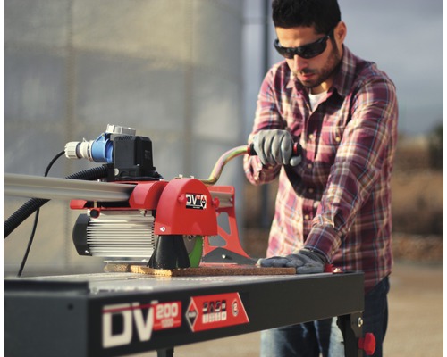 Un homme utilise une carreleuse à l''extérieur.