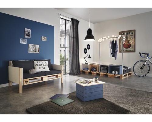 Salon avec meubles en palettes, dont un canapé, une table et un portant