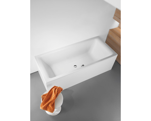 Baignoire rectangulaire en acrylique sanitaire avec trop-plein et serviette sur un tabouret