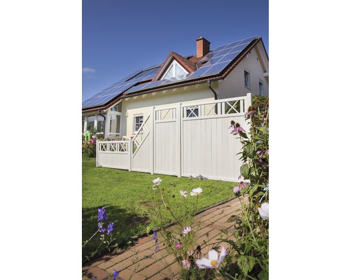 Maison avec panneaux solaires, clôture en bois et jardin