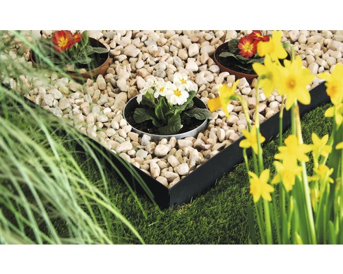 Scène de jardin avec pelouse, pierres, fleurs et bordure métallique pour parterres de fleurs