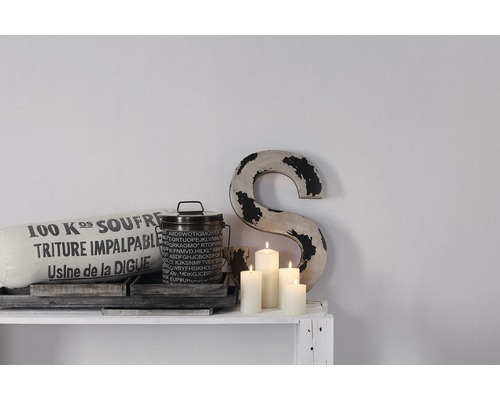 Scène décorative avec coussin, boîte, bougies et une lettre sur une étagère