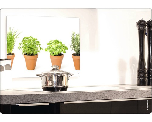 Scène de cuisine avec casserole sur la cuisinière et image d''herbes aromatiques comme protection contre les éclaboussures