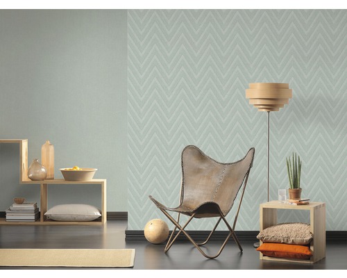 Wohnzimmer mit gemusterter Tapete, Sessel und Beistelltisch