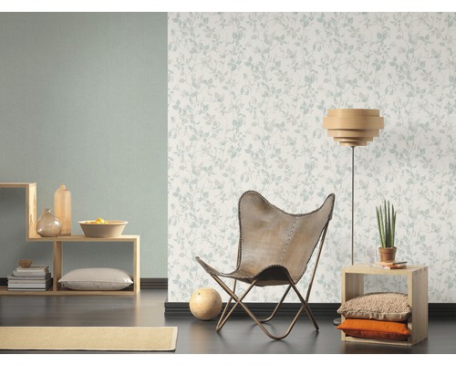 Wohnzimmer mit floral gemusterter Tapete, Sessel und Holzelementen